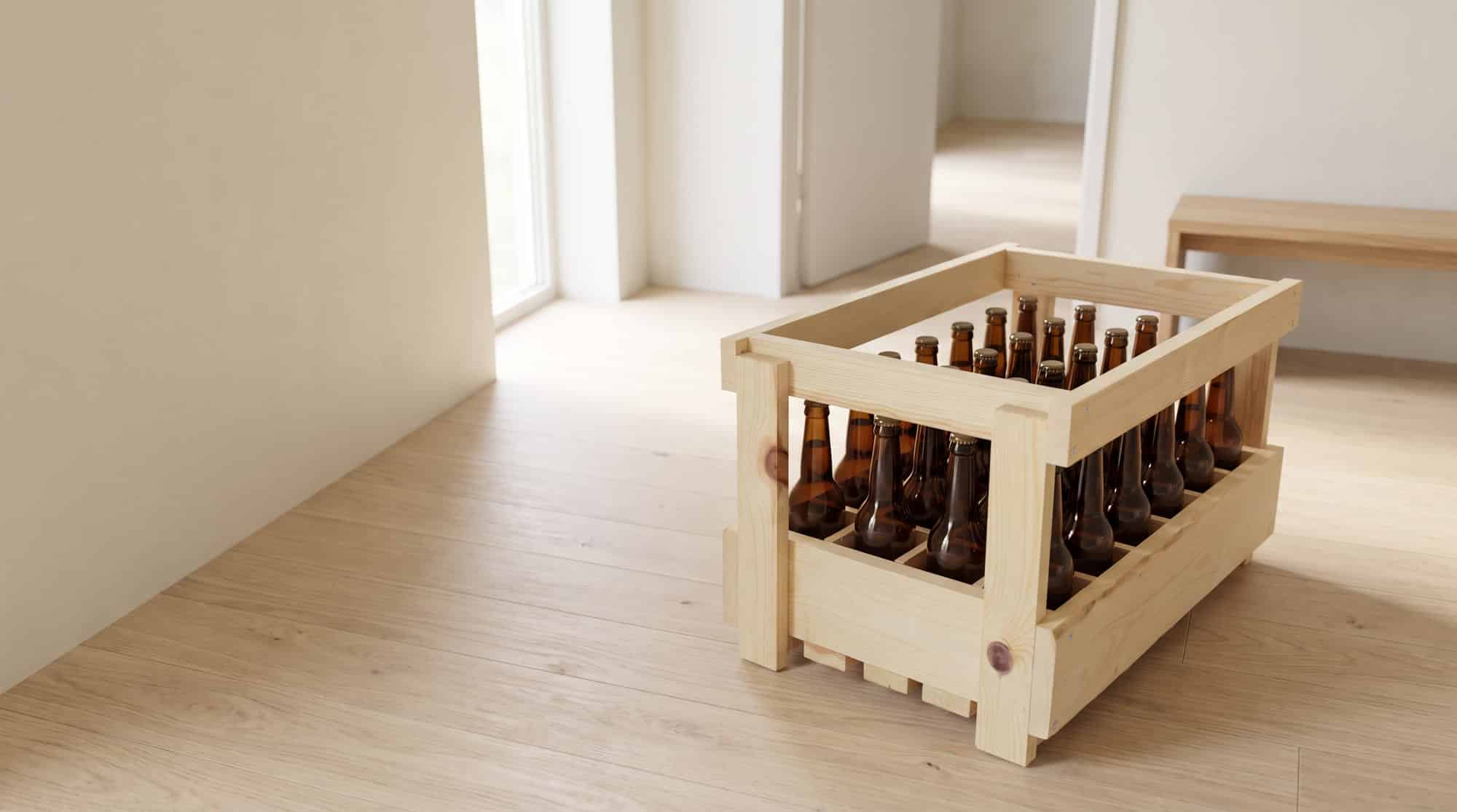 Casier à bière en bois pour 24 bouteilles long neck de 33 cl, rempli, posé sur le parquet clair d'une entrée